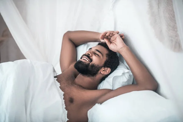 Uomo sorridente con gli occhi chiusi a letto — Foto Stock