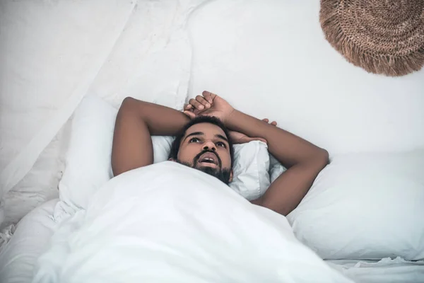 Afroamericano acostado tranquilamente pensando en la cama — Foto de Stock
