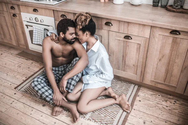 Woman hugging her husband sitting on floor — Stock Photo, Image