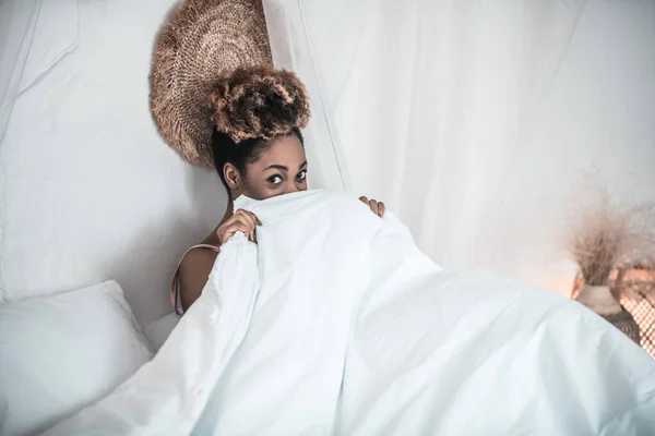 Awakened woman sitting in bed covering blanket — Stock Photo, Image