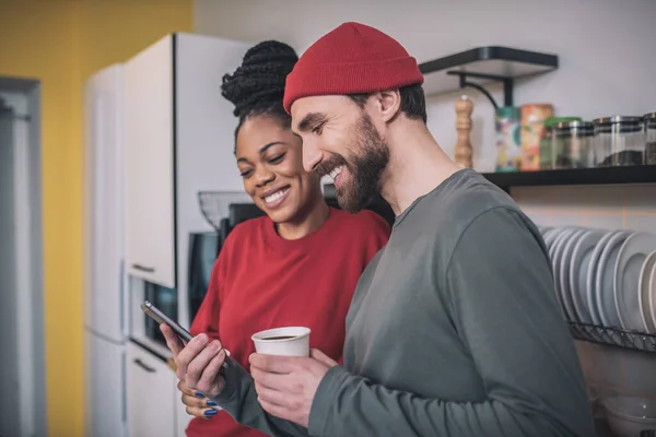 Colegas tomando café en la cocina de la oficina y teniendo una conversación animada —  Fotos de Stock