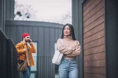 Erkek arkadaşı telefonda konuşurken genç bir kadın sıkılıyor.