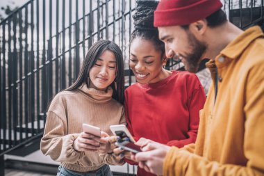 Üç arkadaş birlikte vakit geçiriyorlar ve heyecanlı görünüyorlar.