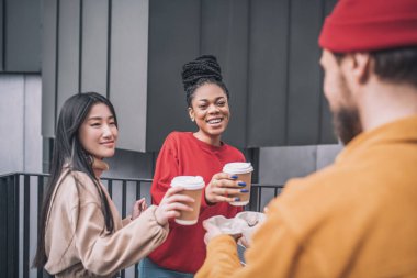 Üç arkadaş kahve içiyor ve birlikte harika hissediyorlar.