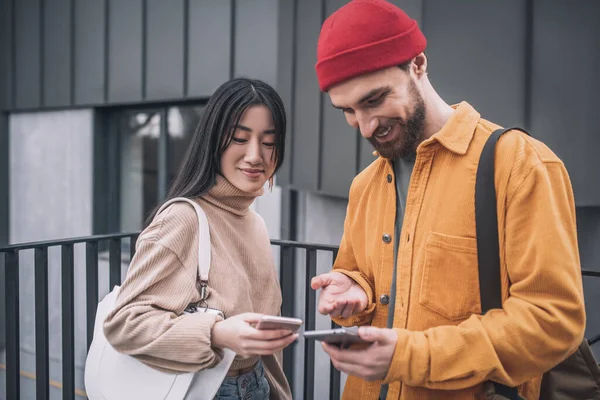 Junges Paar mit Smartphones in der Hand — Stockfoto