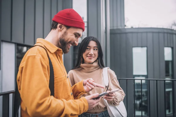 Pareja joven con smartphones en sus manos —  Fotos de Stock