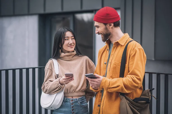 Pareja joven con smartphones en sus manos —  Fotos de Stock