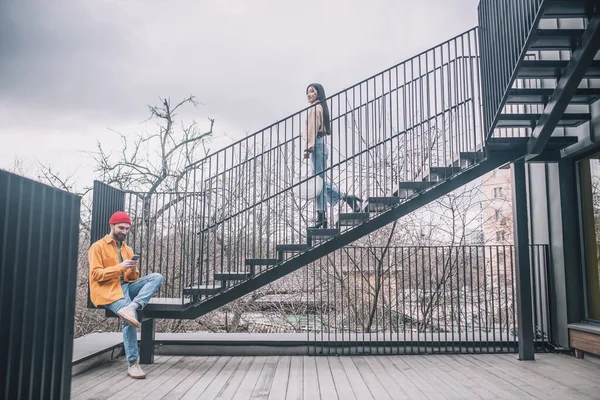 Hombre sentado en las escaleras, la chica bajando en el puente —  Fotos de Stock