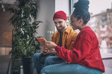 Genç bir adam ve bir kadın konuşuyor ve ilgileniyor.