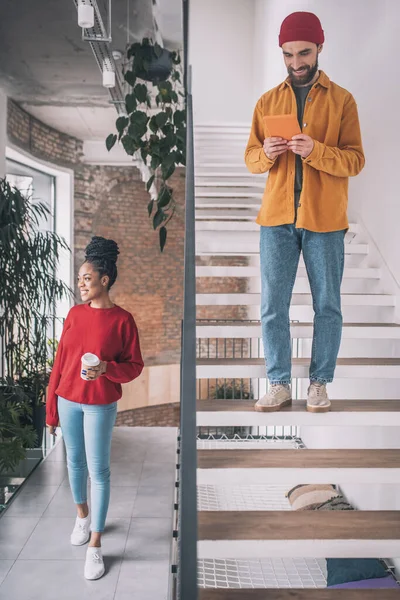 Bild på en man med telefon och en kvinna med kaffekopp — Stockfoto