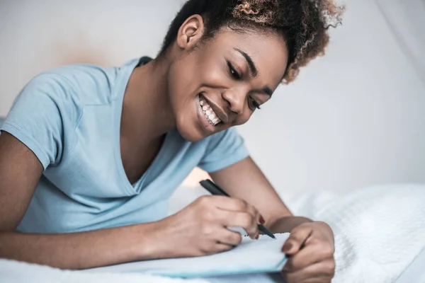 Donna afroamericana che scrive con penna nel taccuino — Foto Stock