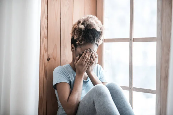 Molesto mujer de piel oscura cubriendo la cara con las manos — Foto de Stock