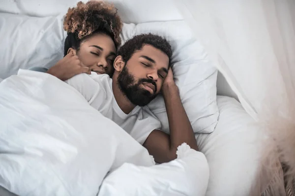 Mujer abrazando hombre durmiendo en casa en la cama — Foto de Stock