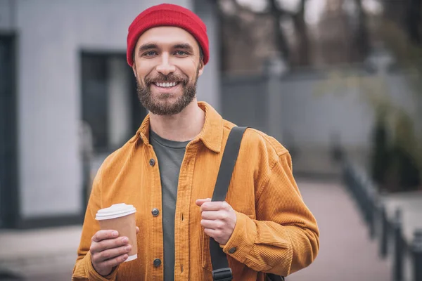 손에 커피 잔을 들고 빨간 모자를 쓴 남자 — 스톡 사진