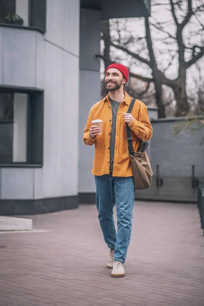 Homme dans une veste orange marchant dans la rue — Photo