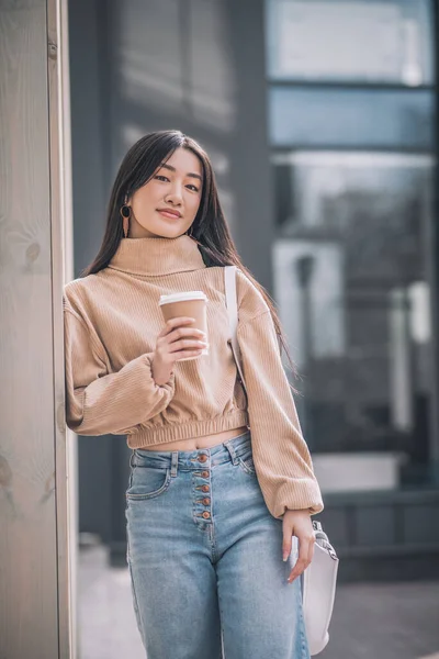 De pelo largo joven asiático mujer tomando café y buscando reflexivo —  Fotos de Stock