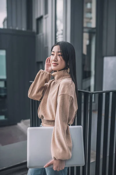 Moda asiático joven mujer de pie al aire libre y buscando bueno —  Fotos de Stock