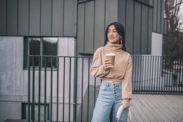 Moda asiático joven mujer de pie al aire libre y buscando bueno —  Fotos de Stock