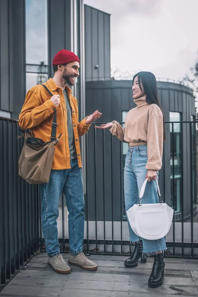 Jeune homme et femme en vêtements décontractés parler à l'extérieur — Photo