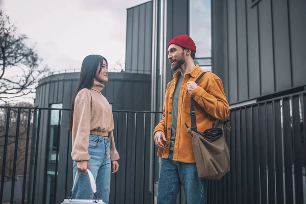 Jovem e mulher em roupas casuais conversando fora — Fotografia de Stock