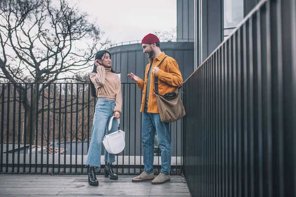 Jeune homme et femme en vêtements décontractés parler à l'extérieur — Photo