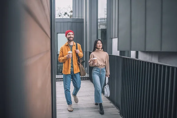 Jovem e mulher em roupas casuais andando juntos — Fotografia de Stock