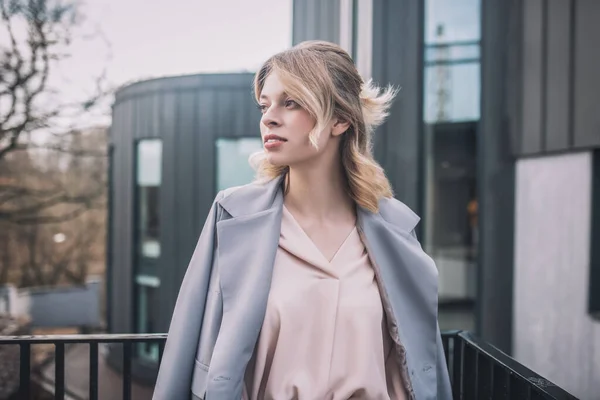 Mujer rubia bonita en la calle mirando a un lado —  Fotos de Stock