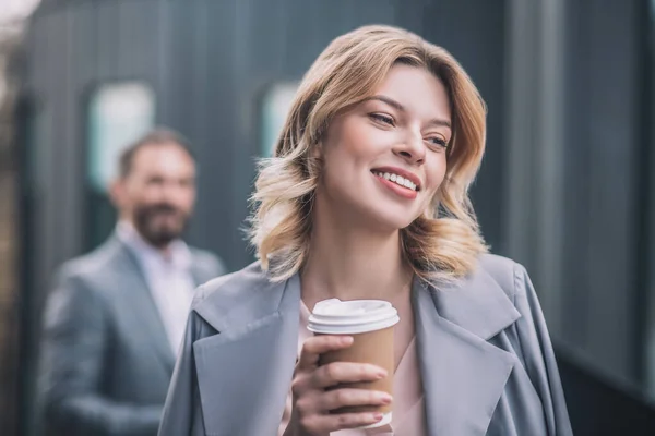 遠くにコーヒーと男と幸せな若い女性 — ストック写真