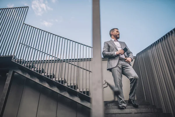 Hombre de negocios parado en peldaños de escaleras al aire libre — Foto de Stock