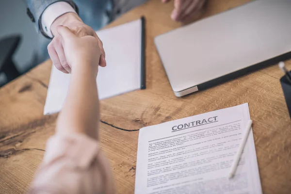 Männliche und weibliche Hände beim Handschlag über den Vertrag — Stockfoto