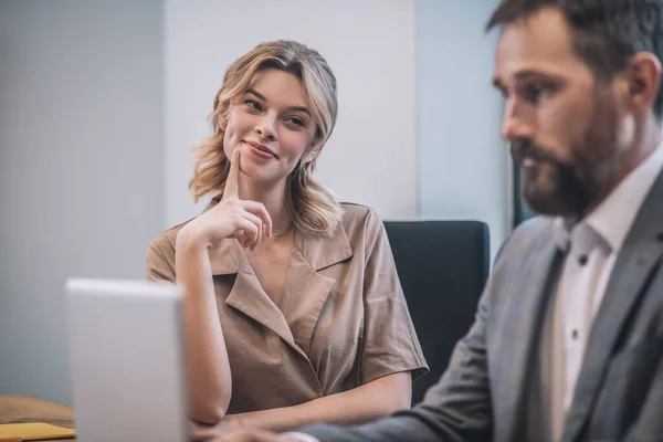 Leende söt kvinna tittar på allvarliga upptagen chef — Stockfoto