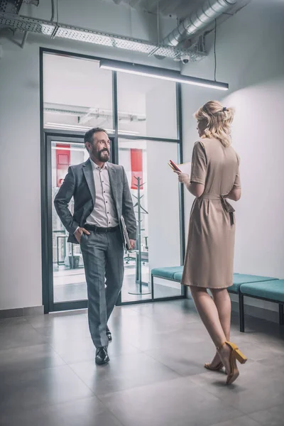 Hombre de negocios alegre caminando hacia la mujer con documentos — Foto de Stock