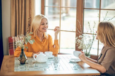 İki güzel kadın birlikte vakit geçirip eğleniyor.