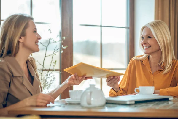 Δύο γυναίκες να μιλάνε και να συζητούν κάτι ενώ κάθονται στο τραπέζι σε ένα καφέ. — Φωτογραφία Αρχείου