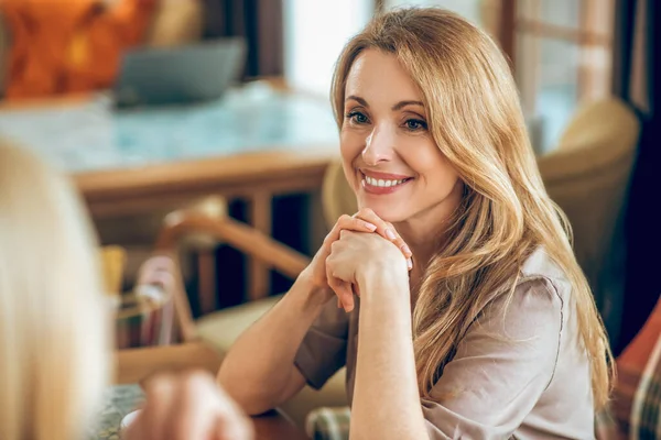 Nette blonde Frau verbringt Zeit mit einem Freund und sieht zufrieden aus — Stockfoto