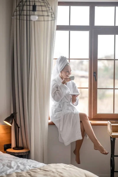 Una mujer con una túnica blanca relajándose después del baño — Foto de Stock