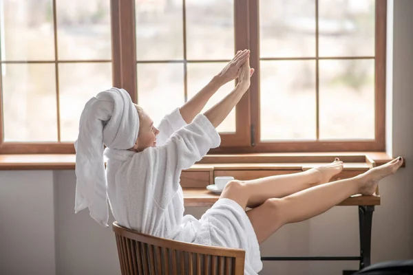 Женщина в белом халате расслабляется дома — стоковое фото