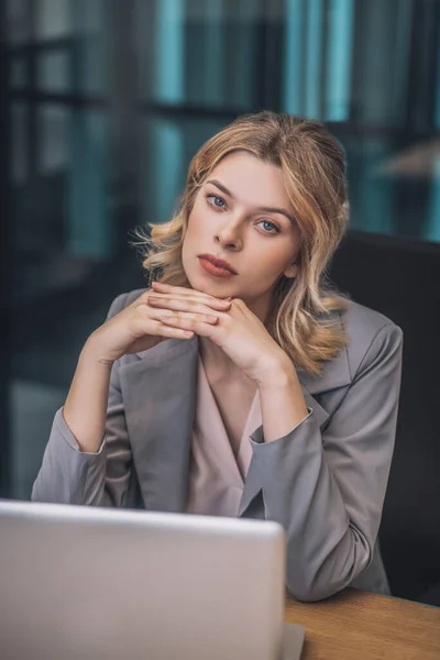 若いですビジネス女性でpensive pose後ろラップトップ — ストック写真