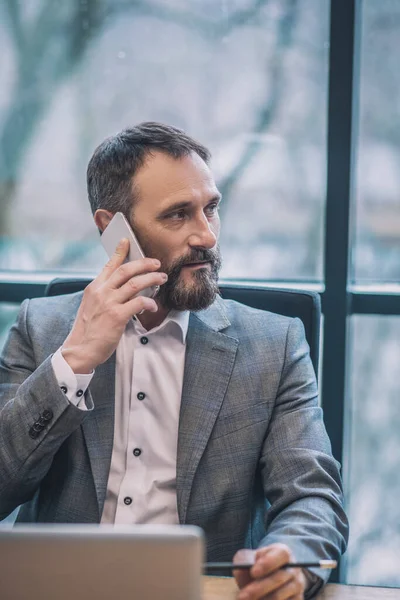 Man met smartphone in de buurt van zijn oor aandachtig luisteren. — Stockfoto