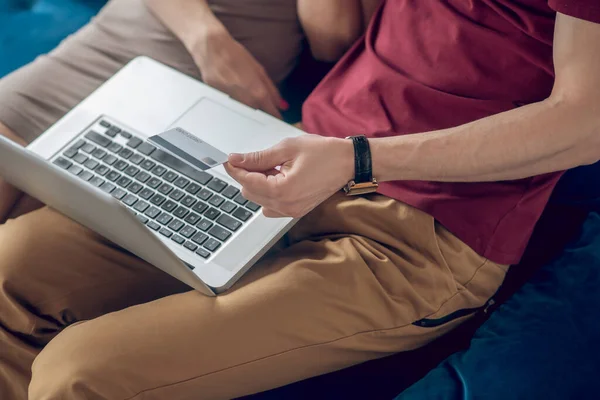 Um homem e uma mulher sentados no sofá com um laptop — Fotografia de Stock