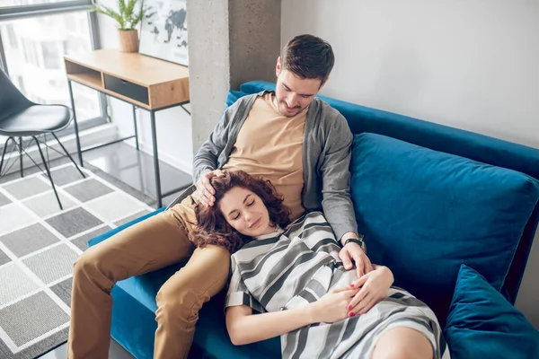 Unga par sitter i soffan och vilar och känner sig förälskade — Stockfoto