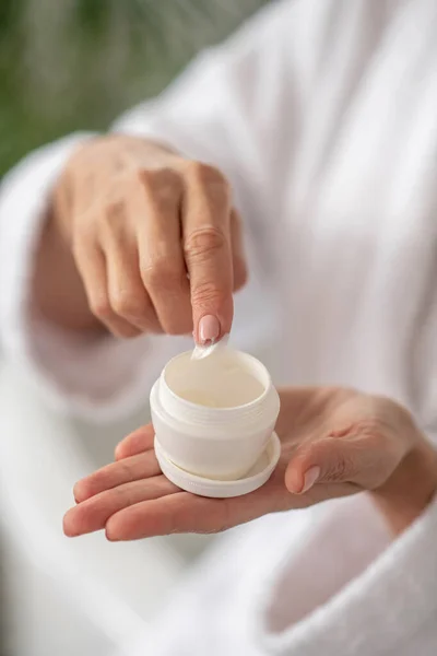 Foto ravvicinata di donne mano ottenere un po 'di crema dal vaso — Foto Stock