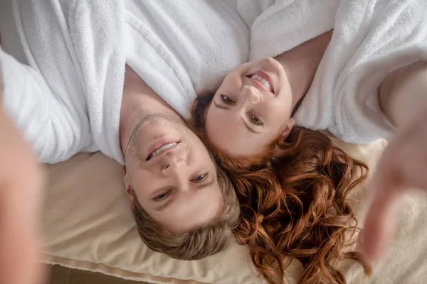 Happy man and woman lying in bed and smiling —  Fotos de Stock