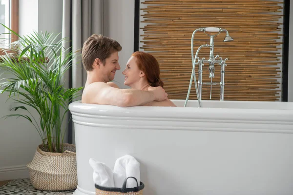 A man and a woman having a bath together and looking excited — стоковое фото