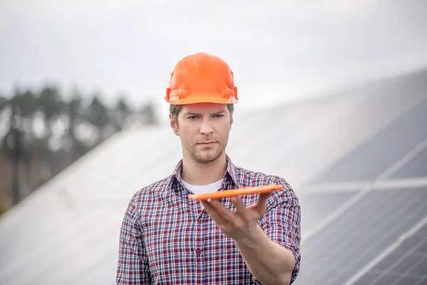 Man in helmet measuring level using tablet — Stock Photo, Image