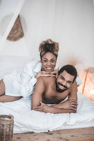 Černý muž a žena ležící ráno na posteli — Stock fotografie