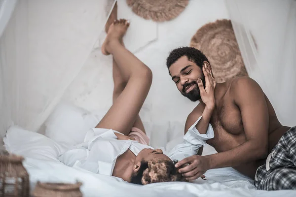 Darkskinned manžel a manželka ležící na posteli těší moment — Stock fotografie