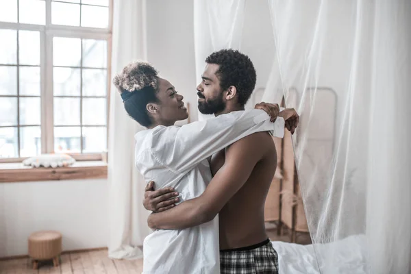Darkskinned man and wife hugging looking at each other — Stock Photo, Image
