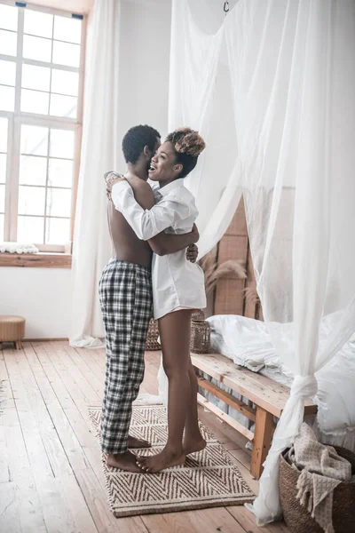 Счастливые темнокожий мужчина и женщина стоят обнимая — стоковое фото