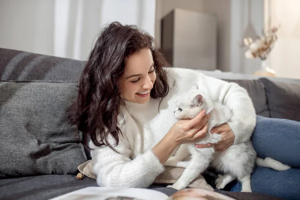 Темноволоса молода жінка з гарним білим котом — стокове фото